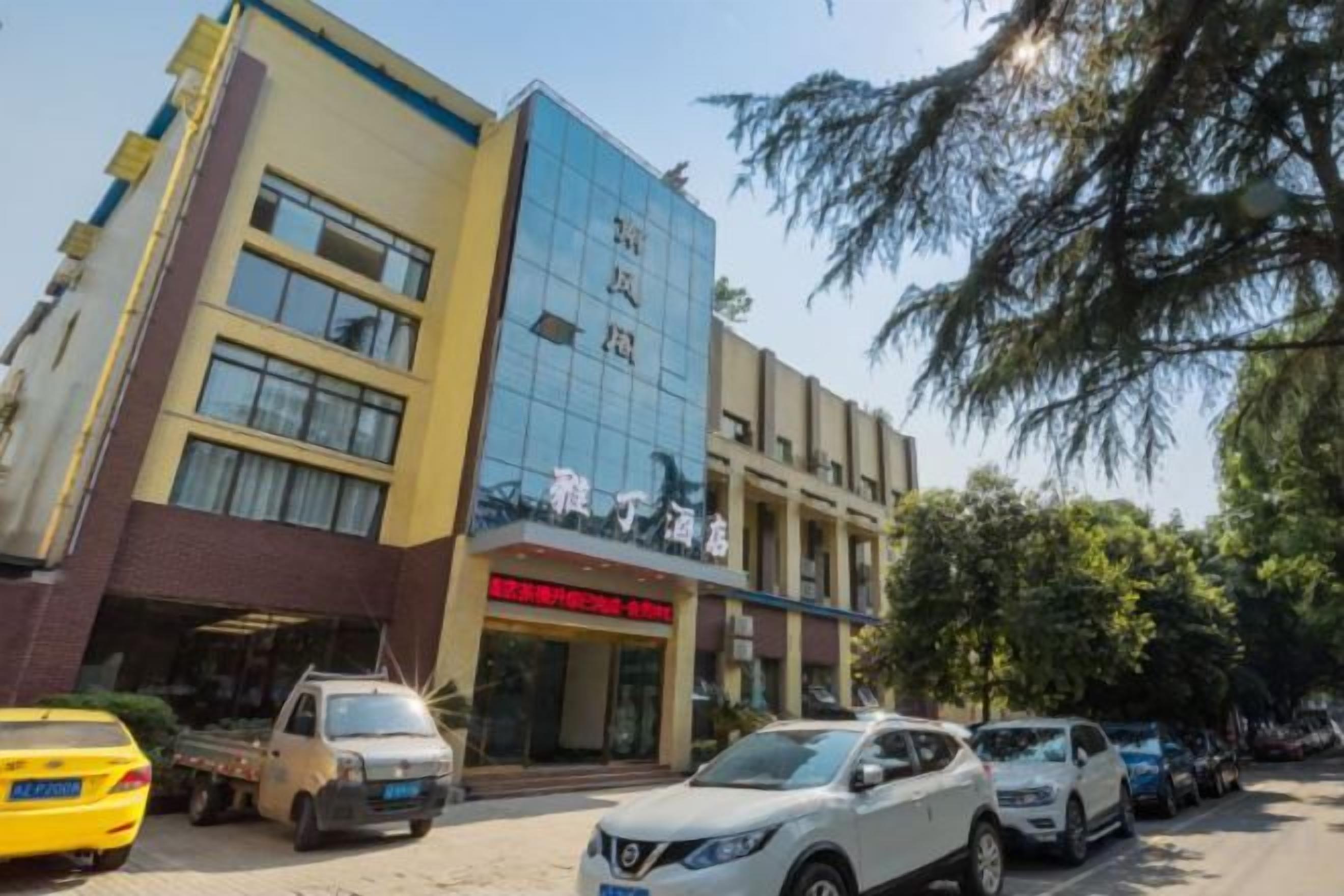 A multi-story building with a commercial ground floor and a parking area in front.