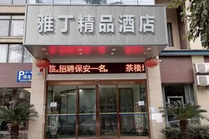 Entrada de hotel con un cartel y un estandarte rojo.