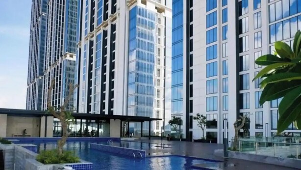 A modern building with a swimming pool, large windows, and a covered area. - Studio Pollux Sea View Apartments

 (Batam City)