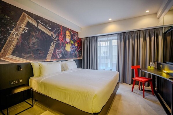 A hotel room with a large bed, a desk with a chair, a TV, and a wall with a large abstract painting. - So City Hotel - Adults Only (St. Julian's)