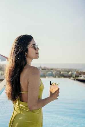 A person standing by a pool with a drink in hand. - So City Hotel - Adults Only (St. Julian's)