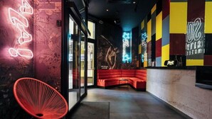 A modern interior with a red seating area, a neon sign, and a glass partition. - So City Hotel - Adults Only (St. Julian's)