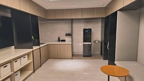 Eine moderne Küche mit Holzausstattung, einem eingebauten Kühlschrank und einem kleinen runden Tisch.