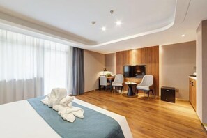 Une chambre d’hôtel moderne, dotée d’un grand lit, d’un bureau et d’une télévision.