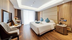 Une chambre d’hôtel moderne équipée d’un grand lit, d’un bureau, d’une chaise et d’un téléviseur.