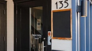 A building entrance with a black door, the number 135, and a sign reading "Hayes Valley." - Inn at Gough (San Francisco)