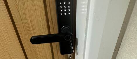 Una puerta de madera con un teclado electrónico negro y una llave insertada.