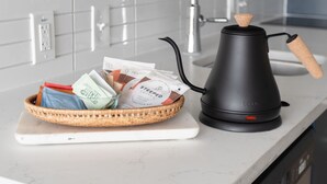 A modern kitchen with a white countertop, a black electric kettle, and a basket of items. -  Studio Haus East 6th Austin by Kasa (Austin)