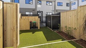 A residential building with a modern design, featuring a central door and multiple windows. - Beachside Townhouse - New Brighton (Christchurch)