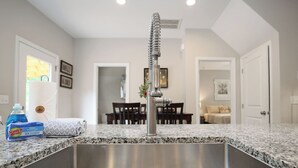 Una cocina con encimera de granito, pileta de acero inoxidable y grifo moderno.