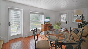 Un salón amplio con una mesa de centro de vidrio, asientos cómodos y ventanas grandes con vistas al exterior.
