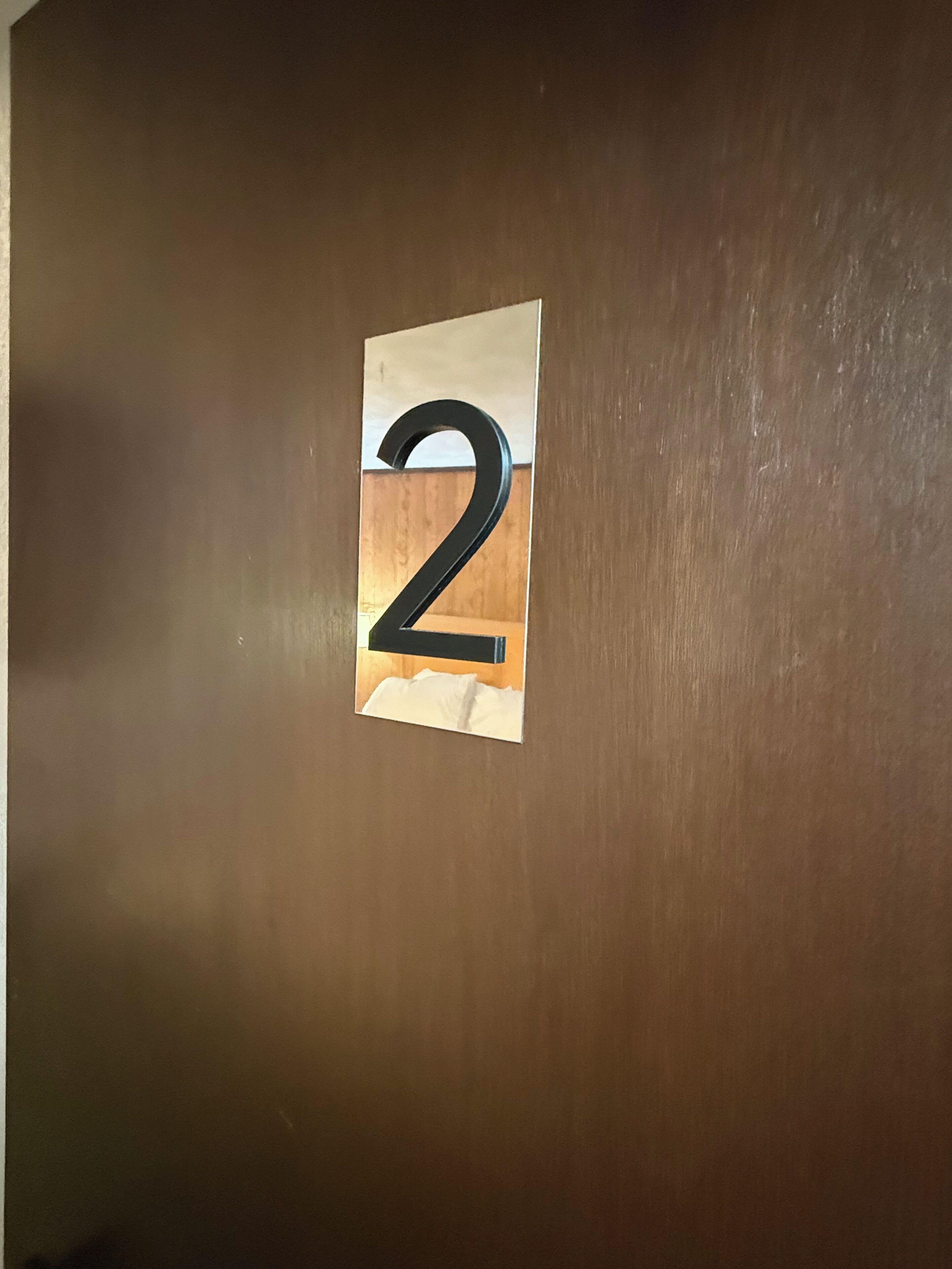 A wooden door with a number '2' sign.