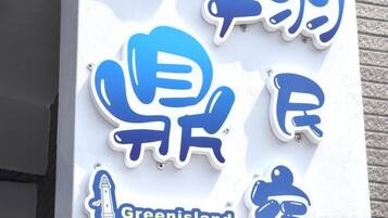 A sign with blue and white text, including the words 'Greenland XiangDing Ban' and a graphic of a person.