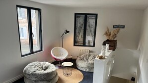 A cozy room with a bed, two bean bags, a chair, a floor lamp, and a radiator. - Cozy cottage in charming Les Andelys with AC, WiFi (Les Andelys)