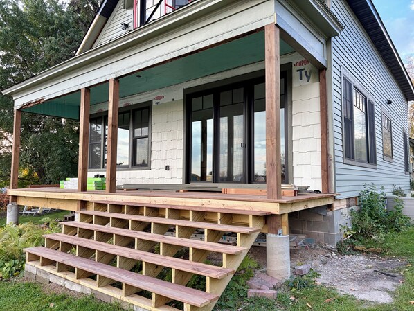 A house with a covered porch, wooden steps, and a window with the name 'DUPONT' on it. - Newly restored! (Warroad)