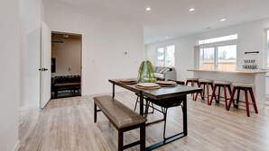 A modern kitchen with a dining area, wooden flooring, and a large window providing natural light. - Brand New Family-Friendly Home for Rent in Battle Ground, WA (Battle Ground)