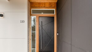A modern entrance with a dark door, a wooden ceiling, and a number '110' on the wall. - Brand New Family-Friendly Home for Rent in Battle Ground, WA (Battle Ground)