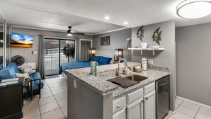 A modern kitchen with a granite countertop, a sink, and a built-in dishwasher.