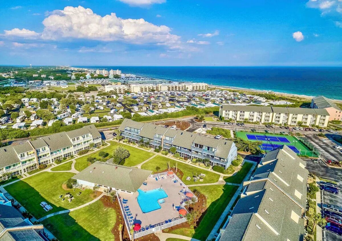 Un complexe hôtelier comprenant plusieurs bâtiments, une piscine et offrant une vue sur la plage.