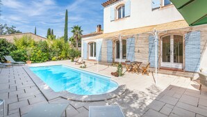 A poolside area with a swimming pool, lounge chairs, and a covered patio. - Villa Azul - Welkeys (Bandol)