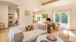 A spacious living area with a sofa, a coffee table, and a dining area with a table and chairs. - Villa Azul - Welkeys (Bandol)