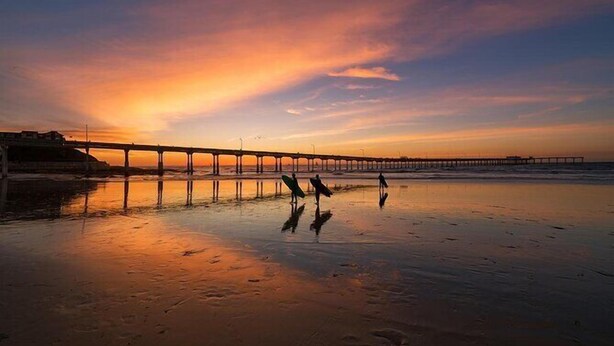 A beach with a pier extending into the water, reflecting the sunset. - 1 Block to Ocean * Brand New Remodel * Dog OK! (San Diego)