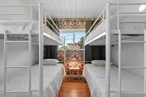 A bunk bed room with a central desk and a window with floral wallpaper. - Sunnyside Resort Spa, Beach, Zoo, Arcade (La Mesa)
