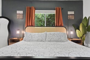 A bedroom with a bed, two bedside tables, a window with curtains, and two wall-mounted lamps. - Sunnyside Resort Spa, Beach, Zoo, Arcade (La Mesa)