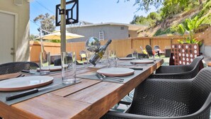 Un área de comedor al aire libre con una mesa de madera, sillas y una bola de discoteca.