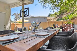 An outdoor dining area with a wooden table, chairs, and a disco ball. - Sunnyside Resort Spa, Beach, Zoo, Arcade (La Mesa)