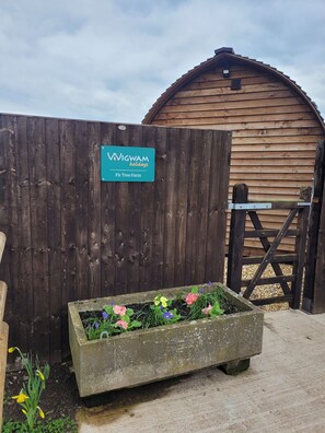 A wooden fence with a sign for VIGWAM holidays and Fir Tree Farm. - Rural Cosy Cabin with Wood-Fired Hot Tub (Whitchurch)