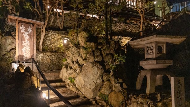 A stone staircase leading up to a traditional Japanese structure with a wooden signboard. - Toraya Bekkan (Kotohira)