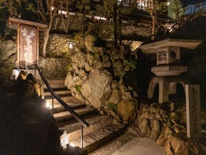 A stone staircase leading up to a traditional Japanese structure with a wooden signboard. - Toraya Bekkan (Kotohira)
