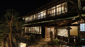 A traditional Japanese building with a two-story structure, a stone pathway leading to the entrance, and a lantern in the foreground. - Toraya Bekkan (Kotohira)