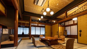 A traditional Japanese room with tatami flooring, a low table, and shoji screens. - Toraya Bekkan (Kotohira)