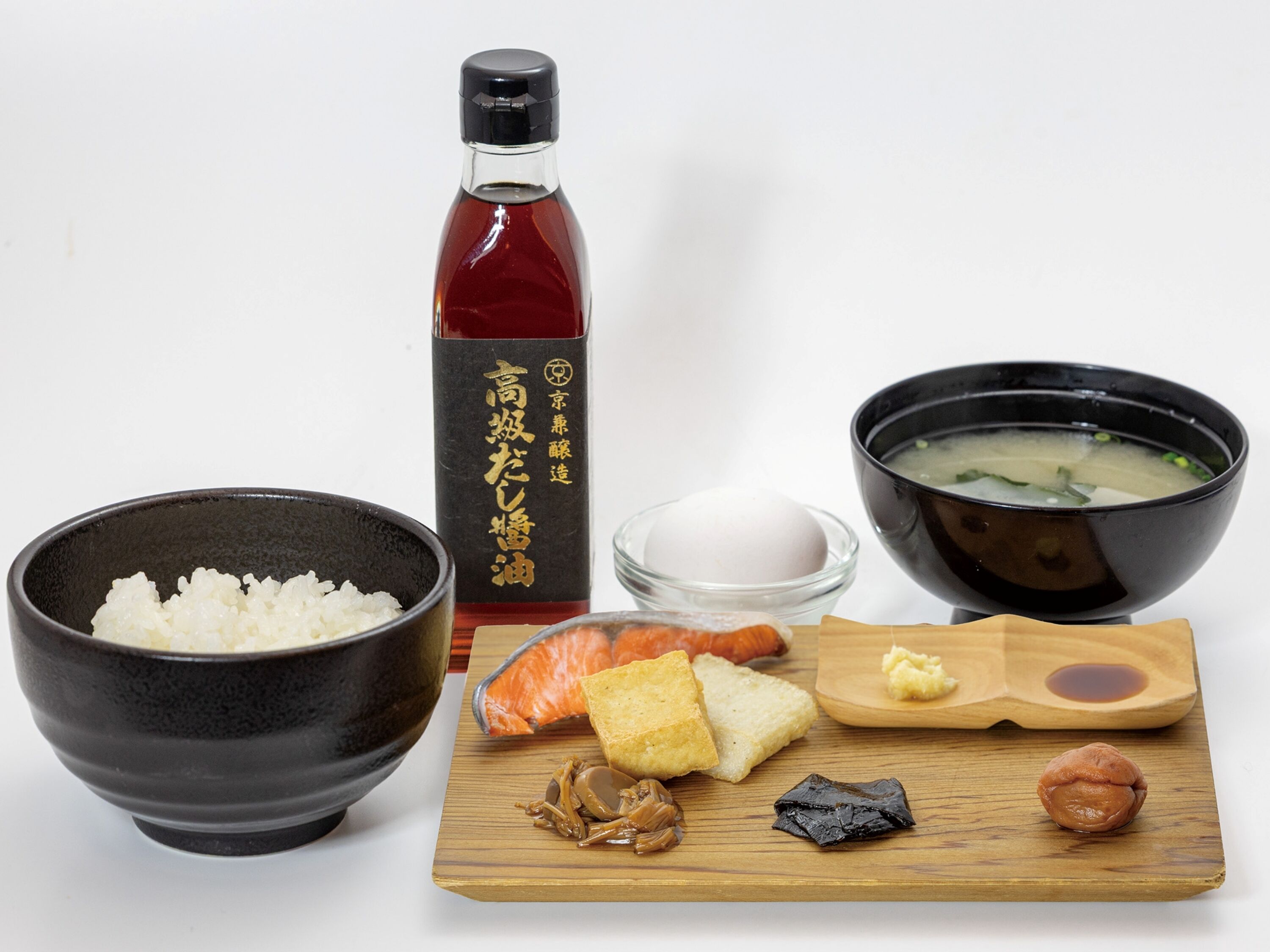 A meal with rice, salmon, tofu, and a soup bowl.
