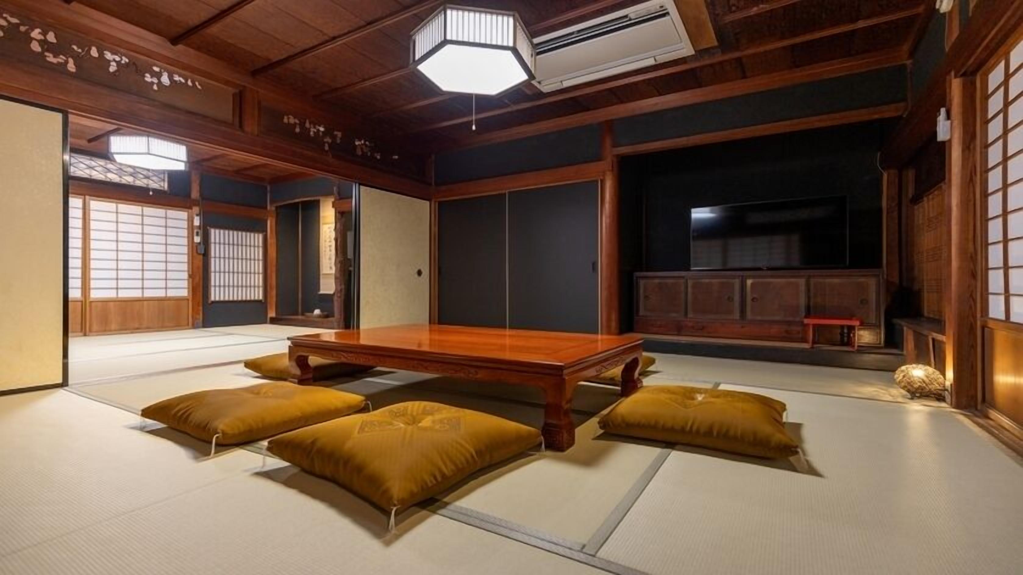Une pièce de style japonais traditionnel, avec un sol recouvert de tatamis, une petite table en bois et des coussins.