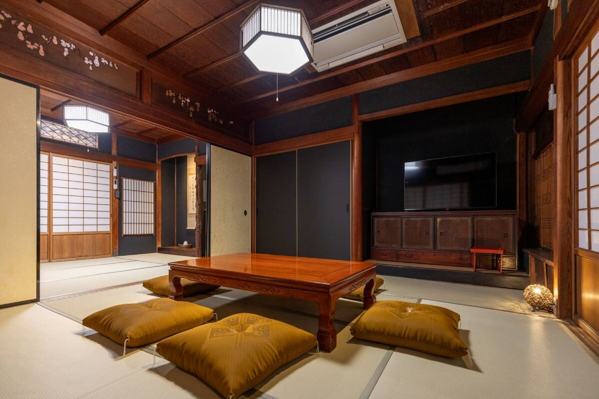 A traditional Japanese room with tatami flooring, a low wooden table, and sliding doors.