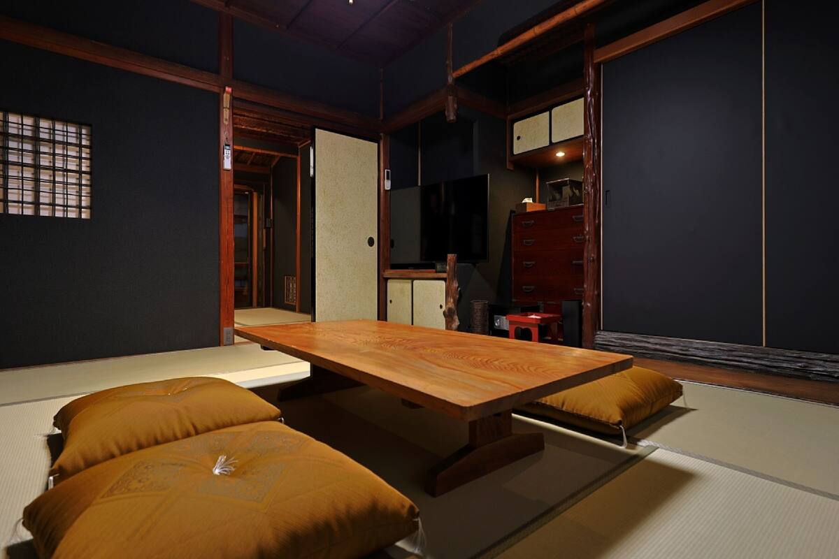 A traditional Japanese room with tatami flooring, a low wooden table, and a sliding door.