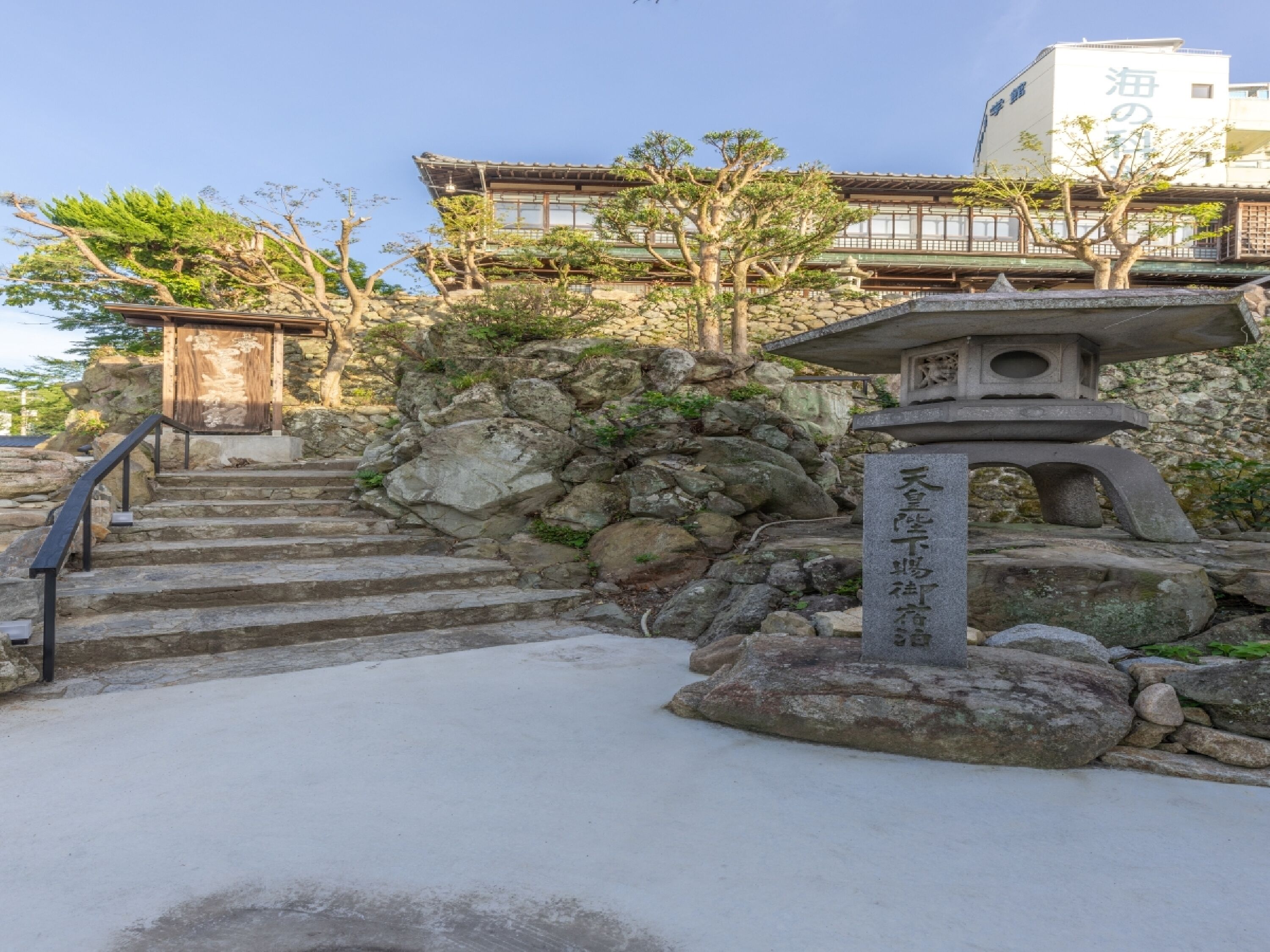 A stone staircase leading up to a traditional Japanese building with a wooden structure at the top.