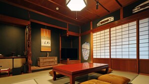 A traditional Japanese tatami room with a low wooden table, cushions, and sliding doors. - Toraya Bekkan (Kotohira)