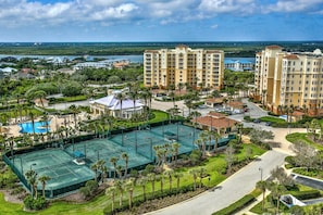 Een hotel met meerdere gebouwen, een tennisbaan en een zwembad.