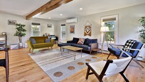 A spacious living room with a wooden ceiling, a sofa, a coffee table, and a chair. - Family Retreat at Lake Bomoseen: Restored 1910s Home, 4BR/2BA (Castleton)