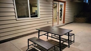 Une terrasse extérieure avec une table et un banc.