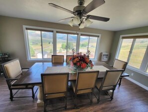Enjoy meals in this dining area with a large table and six chairs, surrounded by natural views and a decorative centerpiece.