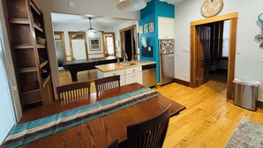 Una cocina moderna con armarios de madera, una isla central y un comedor con camino de mesa a rayas.