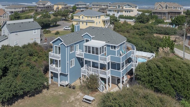 A large, multi-story house with a balcony and a pool, surrounded by other houses and a beach. - 2616 - Bay to Breakers - Semi-Oceanfront Retreat w/ Pool & Hot Tub (Duck)