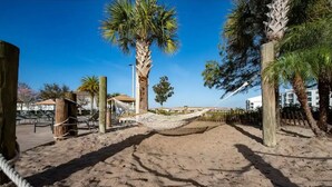 Une plage de sable avec un hamac et des palmiers.