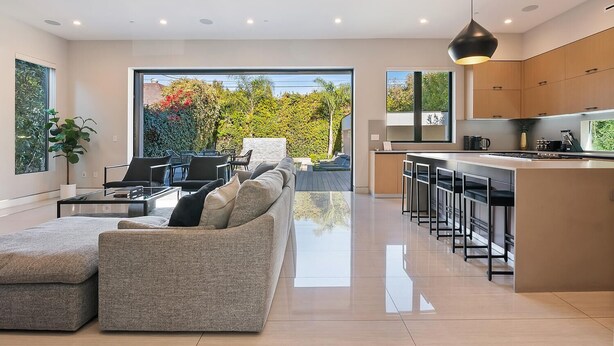 A modern living room with a sofa and a dining area with bar stools. - Chic 4-bedroom villa with WiFi, AC in vibrant Los Angeles (Los Angeles)