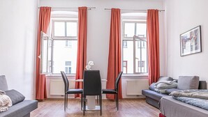 Uma sala moderna com um sofá, uma mesa de jantar com cadeiras e uma cama.
